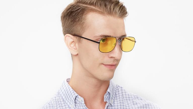 Yellow tinted sunglasses are stylish when paired with brown hair.
